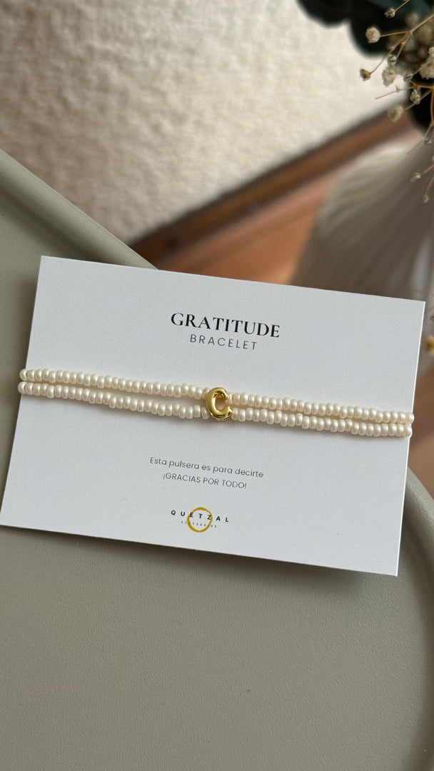 Pulsera doble con inicial de chapa de oro.