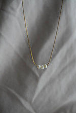 Load image into Gallery viewer, Collar lineal tres perlas de rio con chapa de oro.
