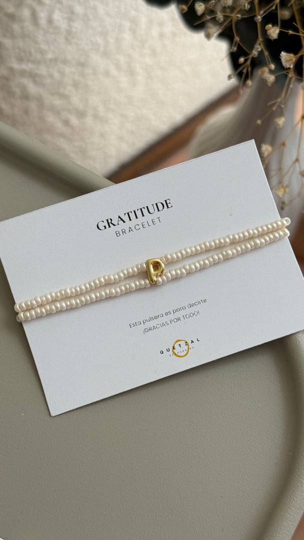 Pulsera doble con inicial de chapa de oro.