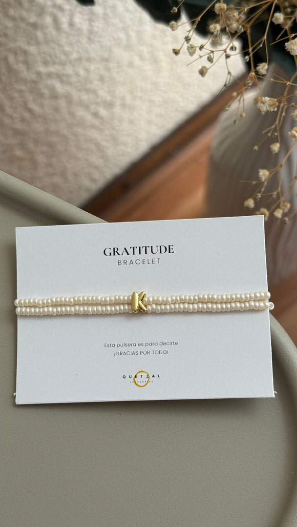 Pulsera doble con inicial de chapa de oro.