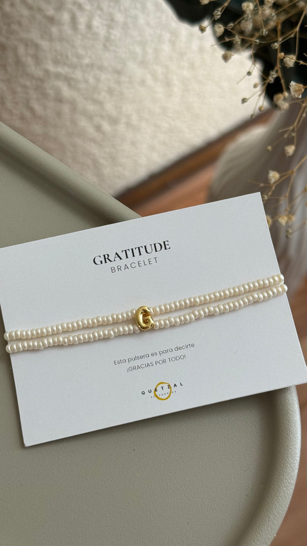 Pulsera doble con inicial de chapa de oro.