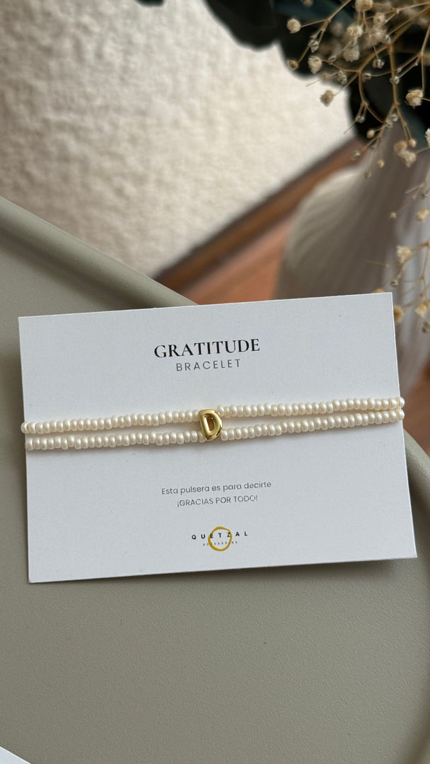 Pulsera doble con inicial de chapa de oro.