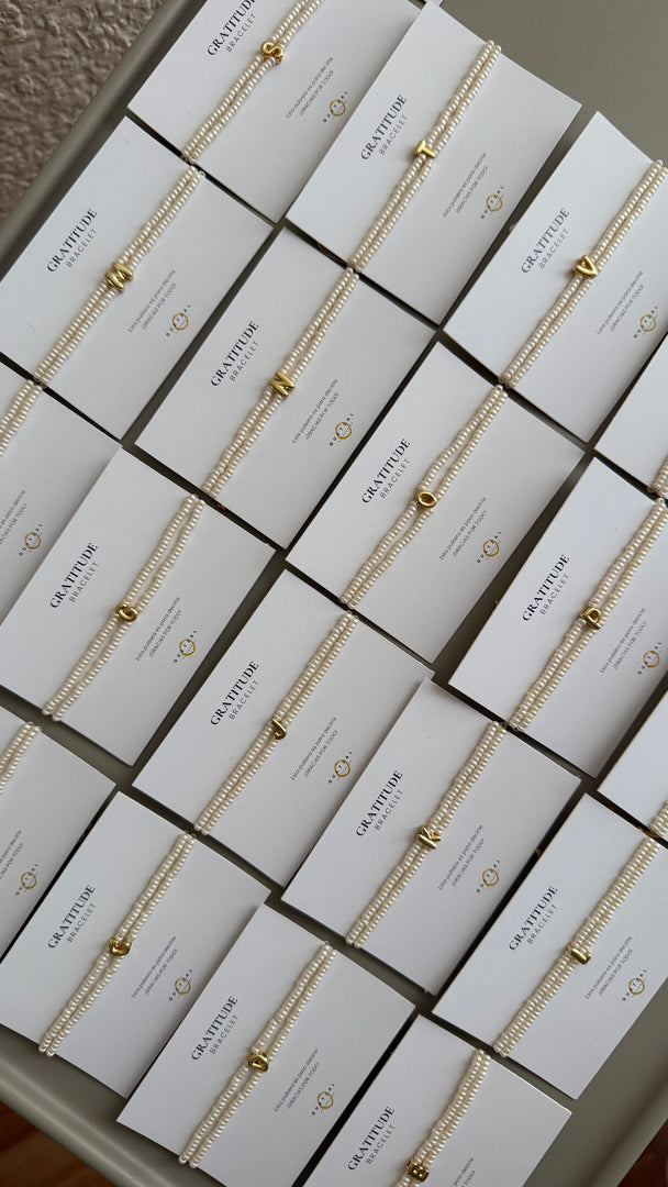 Pulsera doble con inicial de chapa de oro.