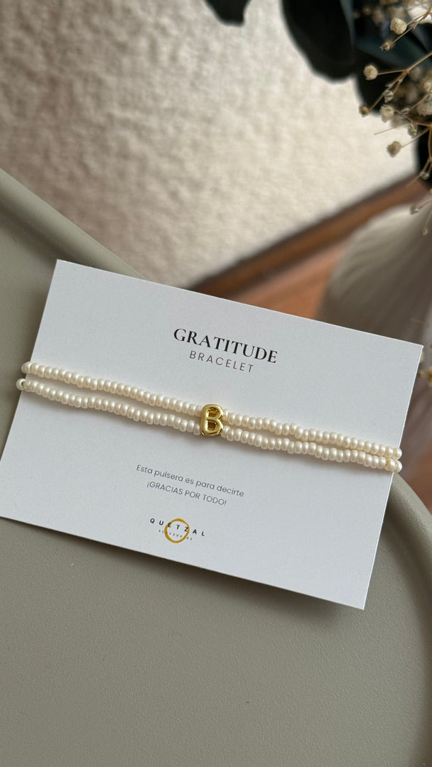 Pulsera doble con inicial de chapa de oro.