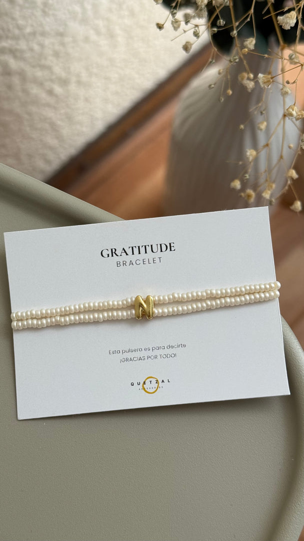 Pulsera doble con inicial de chapa de oro.