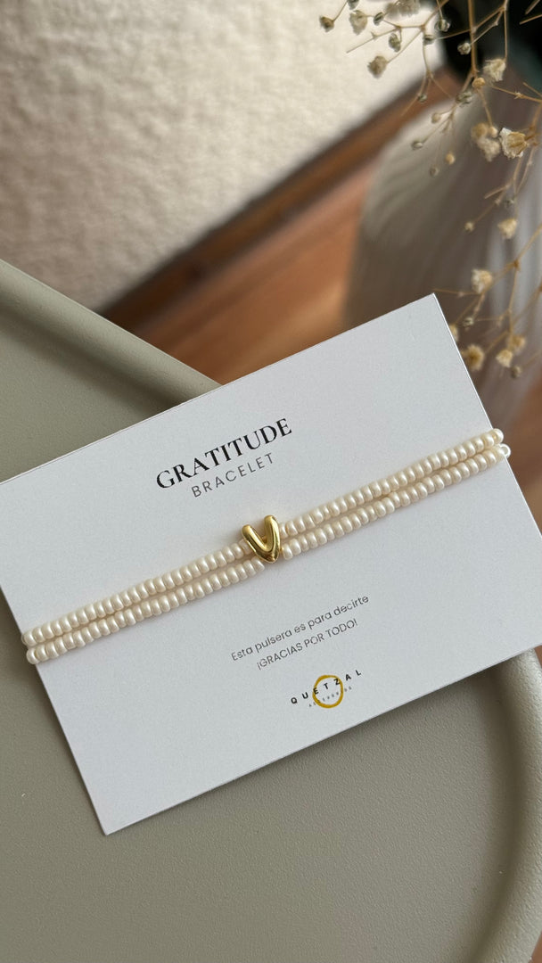 Pulsera doble con inicial de chapa de oro.