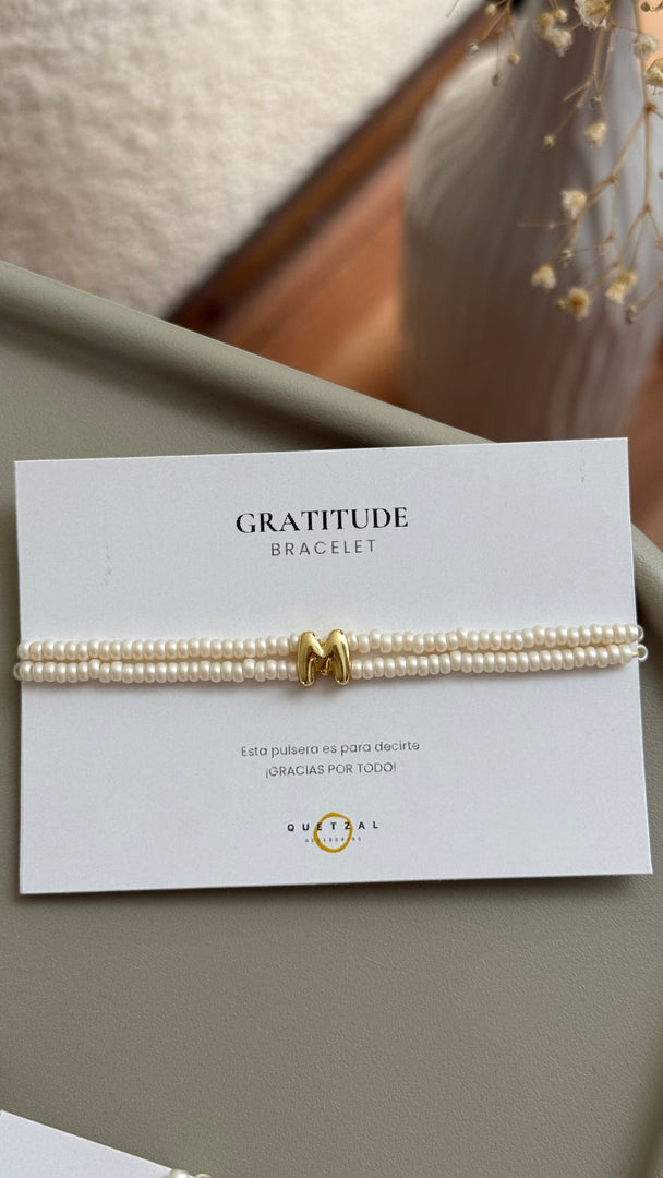 Pulsera doble con inicial de chapa de oro.