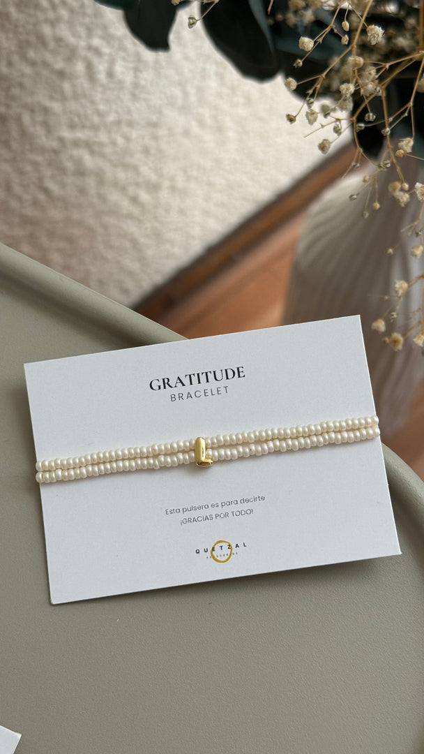 Pulsera doble con inicial de chapa de oro.