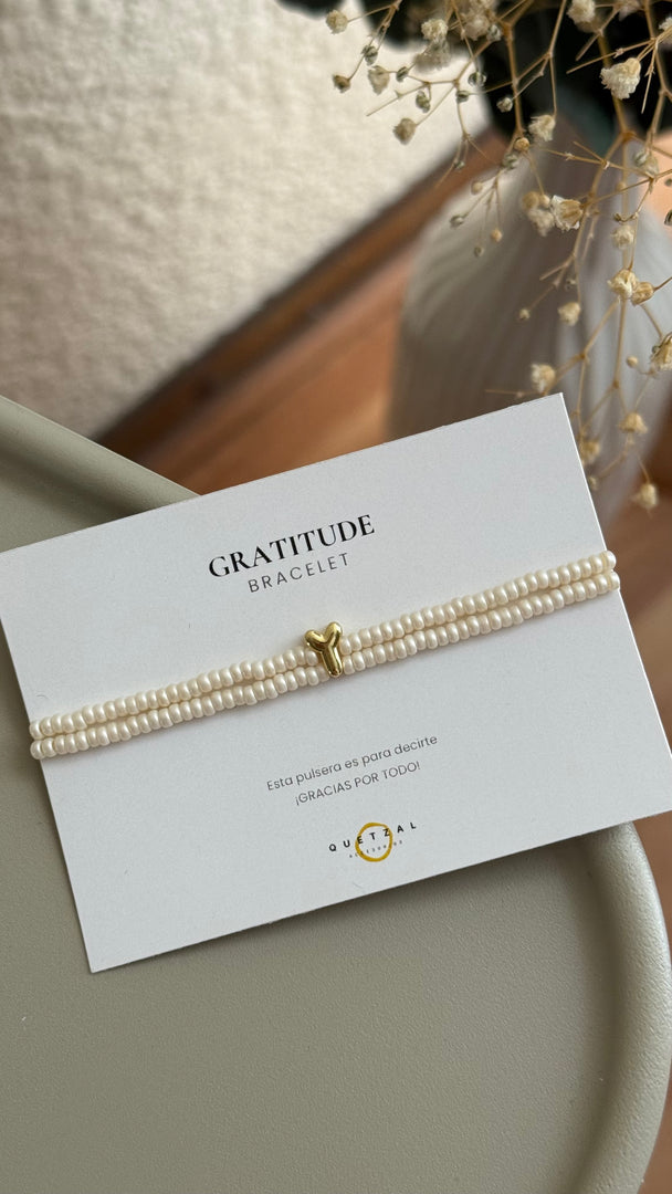 Pulsera doble con inicial de chapa de oro.