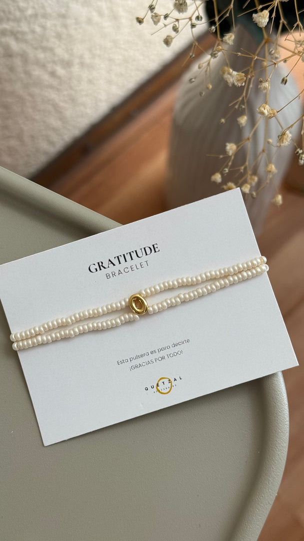 Pulsera doble con inicial de chapa de oro.