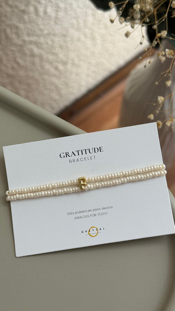 Pulsera doble con inicial de chapa de oro.