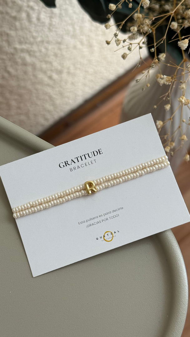 Pulsera doble con inicial de chapa de oro.