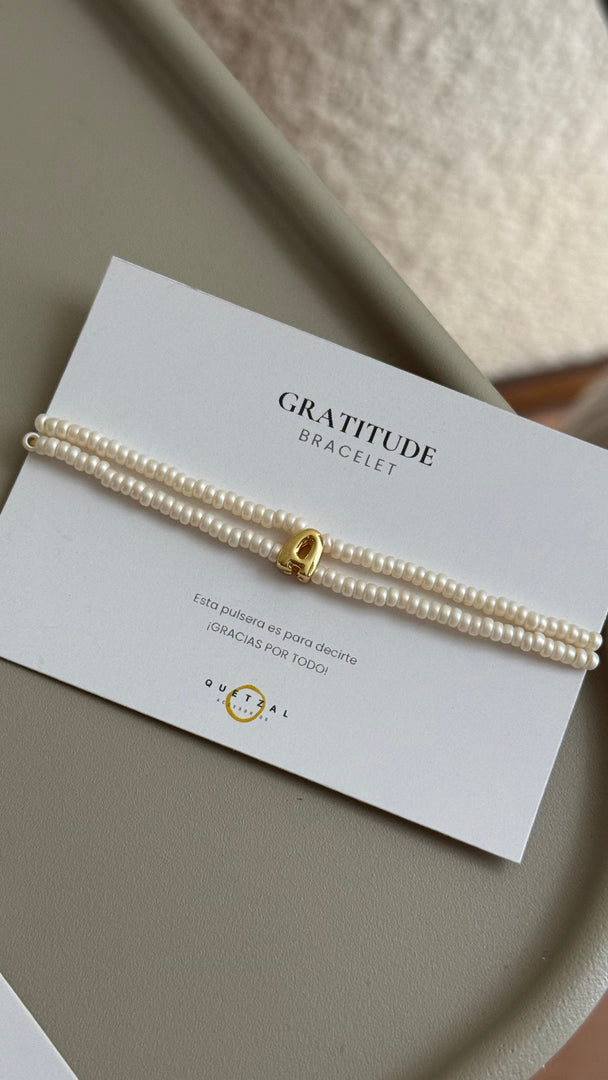 Pulsera doble con inicial de chapa de oro.