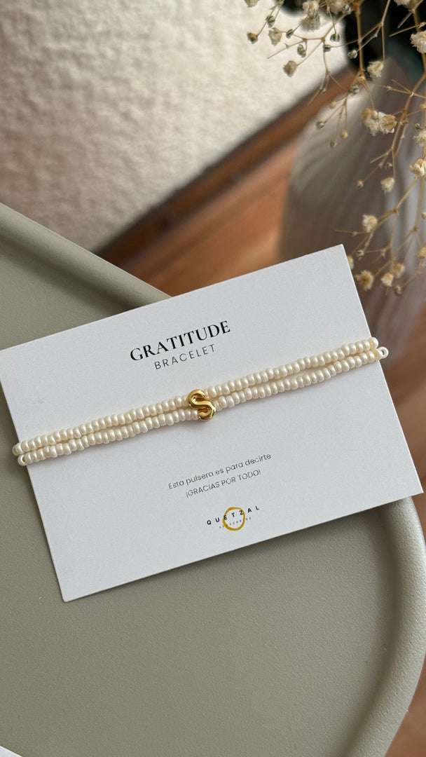 Pulsera doble con inicial de chapa de oro.